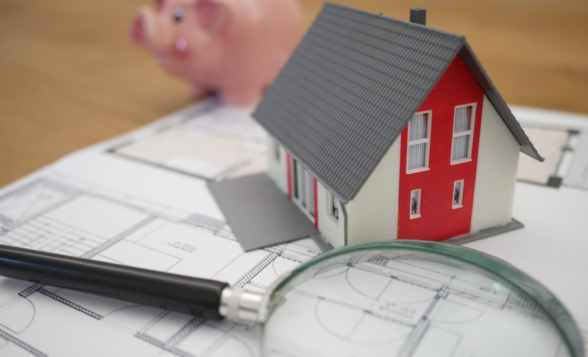 white and red wooden house beside grey framed magnifying glass