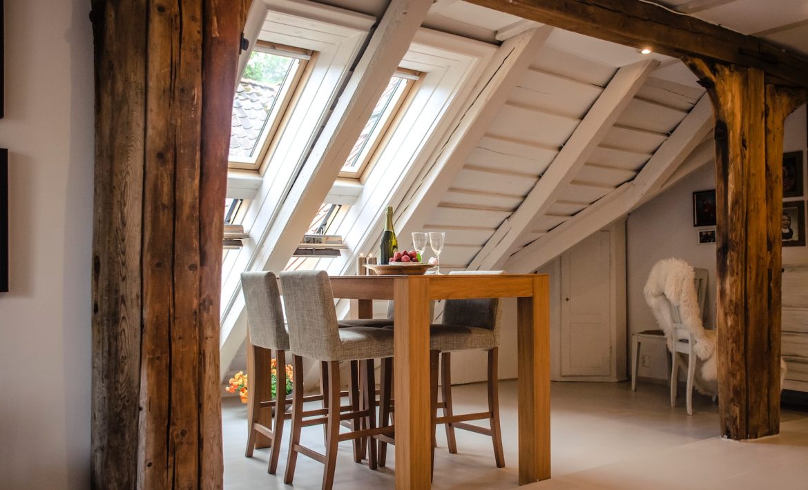 brown wooden dining table with two gray seats near opened window