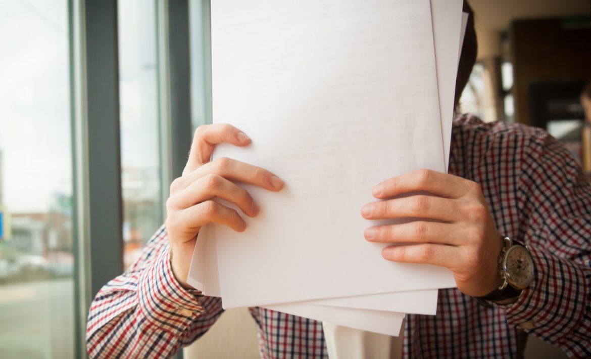 person holding white printer paper